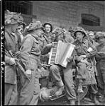 Personnel of the Highland Light Infantry of Canada taking part in singsong. (Left to right at centre): Capt. Rev. J.M. Anderson, Capt. G.D. Sim, S/Sgt. A.H. Eldred 20 June 1944