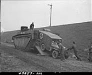 Loading a jeep ambulance into a buffalo 13 Apr. 1945