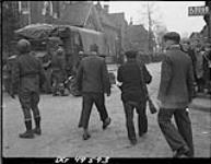 Dutch partisans walking down a street, rounding up collaborators, Holten, Netherlands, 9 April 1945 9 Apr. 1945