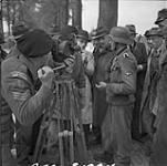 German soldier talking with Canadian driver bringing food to German-occupied area between Weningen and Rhennan. Cameraman is Sergeant D.G. Skene 3 Apr. 1945