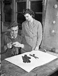 Handicrafts Officer Mrs. Guy Savard of the Canadian Red Cross instructing Private E.L. Woods in glovemaking at No.18 Canadian General Hospital, Royal Canadian Army Medical Corps (R.C.A.M.C.), Colchester, England, 15 December 1944 Deember 15, 1944.