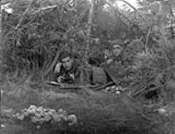 Privates H. Drake and J.R. Dean of the 48th Highlanders of Canada in a camouflaged observation post during manoeuvres, England, ca. 1941 [c.a.1941]