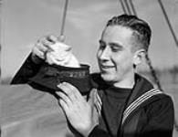 Able Seaman Daniel Ralph with the mascot of the patrol vessel ALLAVERDY of the Fishermen's Reserve, Esquimalt, British Columbia, Canada, 8 November 1941 November 8, 1941.