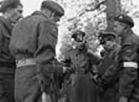 Major K. Henninger (centre), a German Army signals officer, speaking on a telephone linkup between Canadian and German forces, Wageningen, Netherlands, 5 May 1945 May 5, 1945.
