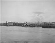 View from riverside of Tidewater Shipbuilders Ltd. Tugs JAMES WHALEN and L. PAUL in channel ca. 1920