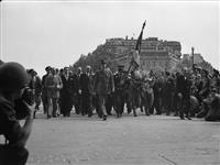 Gen. Charles de Gaulle with French Army officials approaching Arc de Triomphe to place a wreath on the grave of the 'Unknown Soldier' 26 Aug. 1944