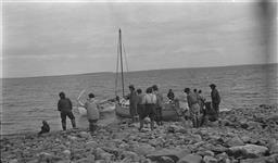 Inuit loading boats in preparation for trip inland after autumn caribou hunt, unidentified location in the Canadian Arctic ca. 1935