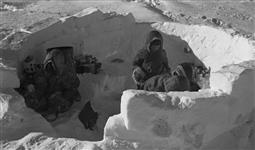 Inuit children play in an unfinished igloo in the Canadian Arctic ca. 1935