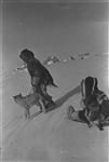 David Marsh in caribou outfit on a sled ca. 1939
