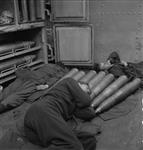 Four-inch gun shells provide a pillow for A/B Bob Harper of H.M.C.S. UGANDA Apr. 1945