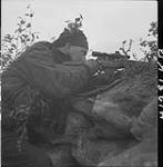 Corporal Arnold, Queen's Own Cameron Highlanders of Canada, using telescopic sight of sniper 9 Ot. 1944