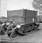 Private J.D. Hamilton stencilling a maple leaf on a Universal Carrier of The Highland Light Infantry of Canada, England, 19 May 1944 May 19, 1944.