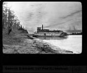 Early morning on the Athabasca River, the H.B. steamer tied up to take wood aboard. Athabasca River, N.W.T., 1928 1928