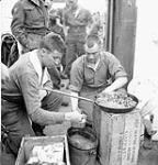 Infantrymen of The Highland Light Infantry of Canada cooking a meal aboard LCI(L) 306 of the 2nd Canadian (262nd RN) Flotilla en route to France on D-Day, 6 June 1944 June 6, 1944.