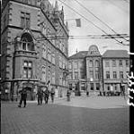 Fusiliers Mont-Royal patrol passing city hall where the Canadian flag has been placed on the mast. Oldenburg, Germany, 3 May 1945 3 MAY 1945