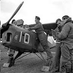 Captain A.G. Dick receives final instructions from Captain Pat Henderson as Leading Aircraftsmen Robert Ducroq and E.J. Edwards service his Taylorcraft Auster A.O.P. III aircraft of the Royal Air Force, Orsogna, Italy, February 1944 February 1944.