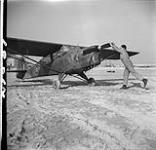 Cpl. David Dumphries twisting aircraft propellor for Capt. Tom Thompso, Ortona (beach), Italy, Feb. 1944 FEB. 1944