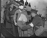 Wounded crewman of the German submarine U-845 disembarking from H.M.C.S. ST. LAURENT en route to hospital 27 mars 1944