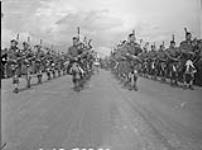 Massed pipe band from Second Canadian Division units, including the Essex Scottish, Toronto Scottish, Calgary Highlanders, Black Watch, Queens Own Cameron Highlanders, during the Dominion Day celebrations at July 1, 1945.