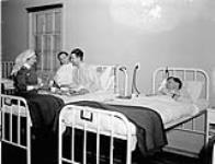 Nursing sisters and patients in a ward at the Royal Canadian Naval Hospital, St. John's, Newfoundland, 23 March 1942 March 23, 1942.