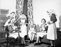 Nursing sisters having tea at the Royal Canadian Naval Hospital, St. John's, Newfoundland, 10 July 1942 [The woman second from the right has been identified by her daughter as Jessie M. R. Muir] July 10, 1942.