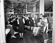 Nursing sisters and patients singing carols at the Royal Canadian Naval Hospital, St. John's, Newfoundland, 21 December 1944 December 21, 1944.