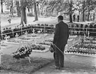 Hon. Ian Mackenzie, Minister of Defense, visiting a small Candian cemetery during his visit to the 5 Canadian Armoured Division. Groningen, Netherlands, 16 July 1945 16-Jul-45
