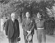 Hon. Ian Mackenzie, Minister of Defense, and others, visiting a small Canadian cemetery during his visit to the 5 Canadian Armoured Division. Groningen, Netherlands, 16 July 1945 16-Jul-45
