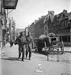 Infantrymen of The Royal Hamilton Light Infantry passing wrecked German wagons, Elbeuf, France, 27 August 1944 August 27, 1944.
