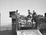 Personnel of The Cameron Highlanders of Ottawa (M.G.) in an Alligator amphibious vehicle on the Rhine River west of Rees, Germany, 24 March 1945 Marh 24, 1945.