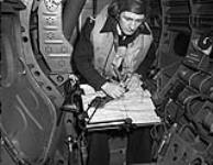 Lieutenant A.W. Turney in the observer's position of a Grumman Avenger aircraft No.852 Squadron, Fleet Air Arm, aboard H.M.S. NABOB, February 1944 February 1944.