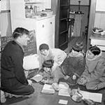 Anglican Missionary Rev. W. James during catechism class with Inuit children at Baker Lake (Qamanittuaq) Federal Hostel, Nunavut, March 1946 Mar. 1946.
