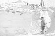 Young Inuk outside igloo 1950