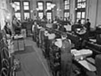Wartime saw Government employees working together in crowded offices such as this room in the Blackburn Building Mar. 1945