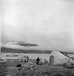 Inuits observant l'arrivée du C.D. Howe, patrouilleur de la région est de l'Arctique July 1951