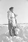 Young Inuit woman standing in the snow at Inukjuak, Nunavik (Quebec) [Martha (née Ipuaraapik) Kasudluak] 1947-1948.