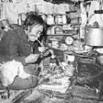 Une femme inuite fabrique une poupée à Igloolik (Iglulik), Nunavut vers 1948-1953.