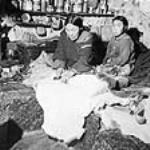 Inuit woman and child preparing a fur skin [Ujaralaaq with her daughter or son. Ujaralaaq is the mother of Celina Irngaut.] n.d.