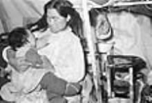 Inuk breastfeeding a baby in a tent [Annie Taliruapik (née Ipuaraapik) Novalinga and her infant daughter Elisapie (née Novalinga) Nutara] 1947-1948.