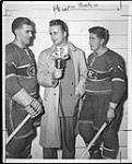 Lloyd Saunders, Regina sports announcer for 'CKCK' doing an interview with Montreal Canadiens' Maurice Richard (left) and Elmer Lack (right) ca. 1948-1949
