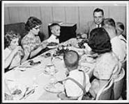 Robert N. Thompson and children at dinner table: (L. to r.) Lois, Alice, Paul, Robert N. Thompson, Mahannen (or Mahennen?), David, Grace and Stephen ca. 1964