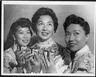 Adding color to festivities on "Women's Day" at the Pacific National Exhibition were the lovely oriental costumes of the servers at afternoon tea. Here are Mrs. Jeanne Yip, Mrs. Charles E. Louie, and Mrs. Harvey Lowe 1959