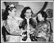 It pays to be good, Arlene Lumb, l., and Lorraine Louie find as they pay their repects to their elders at Chinese New Year's. Mrs. K.S. Lui, their grandmother, gives them their good luck money wrapped in the traditional red paper Feb. 1959