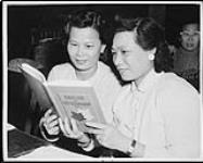 Mrs. Hoy Kam Gee and Mrs. Gam Jou Lee study English and citizenship during a class at the school for adults at the Chinese Presbyterian Church Jan. 1959