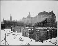 Construction of the Supreme Court of Canada building. View of foundation with Parliament's West Block and Confederation building in background 28 Feb. 1939