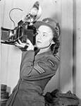 Sergeant Karen M. Hermiston of the Canadian Women's Army Corps (C.W.A.C.), who is holding an Anniversary Speed Graphic camera, London, England, 15 November 1945 November 15,1945.