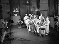 Private H. Roach, a simulated casualty, receives treatment in the operating theatre of No.5 Casualty Clearing Station, Royal Canadian Army Medical Corps (R.C.A.M.C.), Lingfield, England, June 1942 June, 1942.