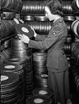 Private Nadine Manning of the Canadian Army Film and Photo Unit in a film vault at Merton Park Studios, London, England, 19 December 1944 Deember 19, 1944
