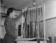 Private Nadine Manning of the Canadian Army Film and Photo Unit processing strips of censored film at Merton Park Studios, London, England, 19 December 1944 Deember 19, 1944