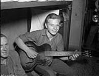 Prisoner playing guitar 7 Feb. 1946